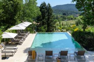 普罗旺斯艾克斯Les Lodges Sainte-Victoire Hotel & Spa的一个带躺椅和遮阳伞的游泳池