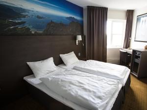 波多Thon PartnerHotel Skagen的卧室配有一张带白色床单和枕头的大床。