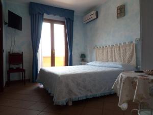 OssiGrotta Delle Fate的卧室配有白色的床和窗户。