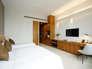 香港悦品天秀酒店 (元朗) 的卧室配有白色的床和平面电视。