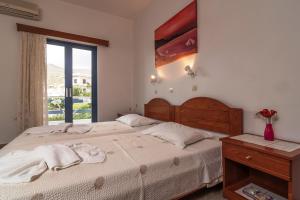 帕琉乔拉Roula Apartments的一间卧室设有一张大床和一个窗户。