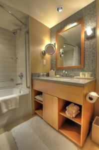 里士满River Rock Casino Hotel的一间带水槽、浴缸和镜子的浴室
