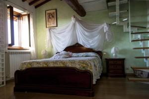 蒙泰斯佩尔托利B&B Il Poggetto的一间卧室配有一张带天蓬的床