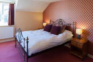 LowdhamUnicorn, Gunthorpe by Marston's Inns的一间卧室配有一张带白色床单和紫色枕头的床