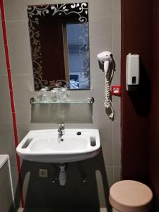 布鲁塞尔列日王子酒店的一间带水槽的浴室和墙上的一部电话