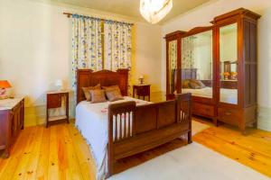 Aguiar de SousaPorto Countryside House的一间卧室配有一张床和一面大镜子