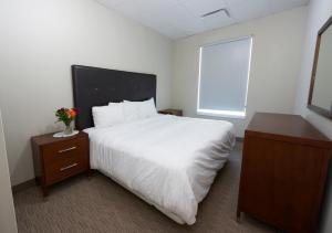 沃萨加比奇海滩Wasaga Riverdocks Hotel Suites的卧室设有一张白色大床和一扇窗户。