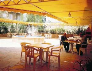 布罗马纳克里隆酒店的两人坐在黄伞下的桌子上