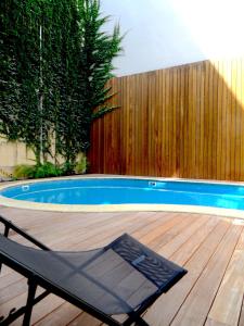 波尔多LOFT luxe hyper centre: terrasse/piscine/ salle de sport的游泳池旁甲板上的椅子
