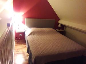 Civray-de-Tourainegite la Pinetterie的一间小卧室,配有一张床和红色的墙壁