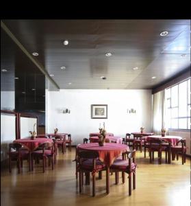 波尔图帕兰卡酒店的一间用餐室,在房间内配有红色的桌子和椅子