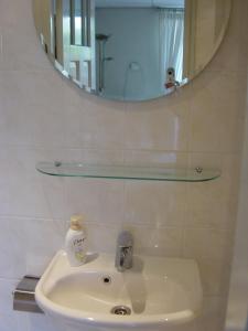 RenkumIt tunhuske的浴室水槽配有镜子和1瓶肥皂