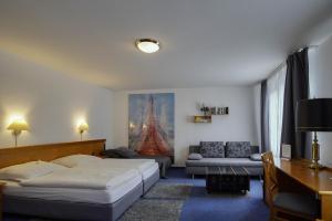 朗根费尔德马克西姆旅馆的一间带两张床的卧室和一间带沙发的客厅