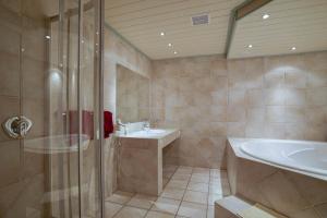 朗根费尔德马克西姆旅馆的带淋浴、盥洗盆和浴缸的浴室
