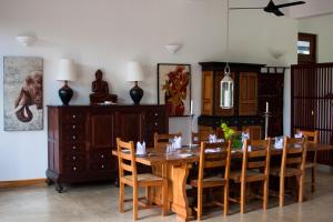Madawala吉姆农场别墅酒店的一间带木桌和椅子的用餐室