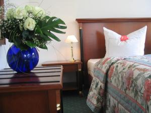圣布拉辛佳尔尼艾希酒店的一间酒店客房,配有蓝色花瓶和花朵