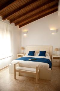 扎霍拉AROHAZ Hotel & Restaurante的白色卧室配有一张带蓝色枕头的大床