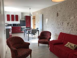 卢瓦尔河畔默恩Gîte du Parc des Mauves的客厅配有红色的沙发、椅子和桌子