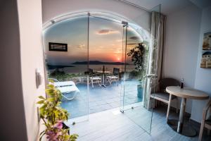 费拉柯乐特乐思唯优奢华套房的一间设有玻璃门的客房,享有日落美景