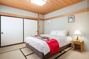 白马村白马酒店的一间卧室配有一张带红色毯子的大床