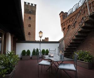 阿斯蒂Castello Medici del Vascello的一个带桌椅的庭院和一个钟楼