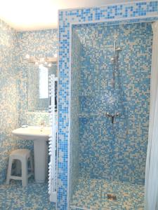 Viréle gîte de viré的蓝色瓷砖浴室配有淋浴和盥洗盆