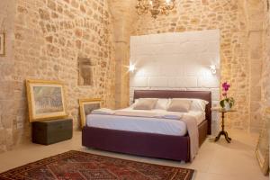 孔韦尔萨诺Dei Balzi Dimore di Charme的卧室设有一张砖墙内的大床