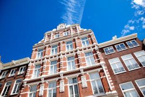 阿姆斯特丹纳斯酒店的红砖建筑,有白色的窗户和蓝色的天空