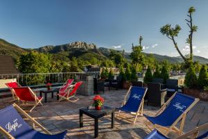 扎科帕内罗格斯酒店的庭院配有桌椅,背景为山脉