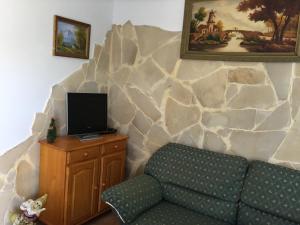 加尔达尔Casa Rural Anzo的带沙发和岩石墙的客厅