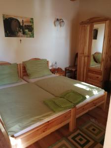 BecsehelyVitis Vendégház的一间卧室配有一张带绿色床单的大床