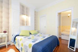 毕尔巴鄂Apartamento frente al Guggenheim con wifi y parking privado gratis的一间卧室配有一张蓝色和黄色毯子的床