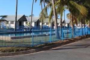 麦凯中央游客公园酒店的棕榈树屋前的蓝色围栏