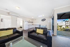莱伊月光湾公寓 的客厅配有两张黑色皮沙发