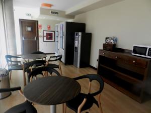巴利亚多利德里奥霍特加酒店的配有2张桌子和椅子以及冰箱的房间