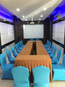 巴淡岛中心OS Hotel Airport Batam的一间会议室,配有长桌子和蓝色椅子