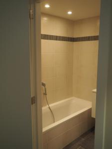 科克赛德Appartement "FD"的带浴缸和卫生间的浴室。