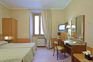罗马博物馆酒店的酒店客房带一张床、一张书桌和一面镜子
