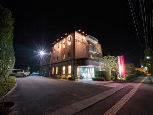 Kurihara安倍附楼酒店的一座大型建筑,晚上有灯在旁边