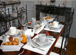 勒芒德摩尔拉科莱酒店的一张木桌,上面有盘子和杯子,上面有盘子