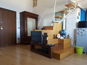 焦维纳佐La Finestra sul Mare的客厅设有电视,位于木制娱乐中心