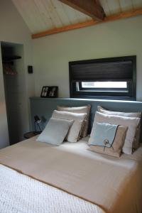沃德里赫姆Hoeve Altena Guesthouse的卧室配有带枕头的大床和窗户。