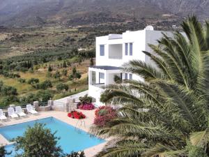 莱弗考基亚Modish Villa in Lefkogia Crete with Swimming Pool的一座别墅,设有游泳池和棕榈树