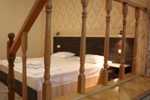 第比利斯天堂酒店的卧室内的一张带白色床单和枕头的床
