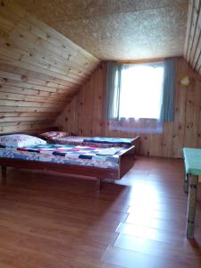 阿格洛纳Priedīši的木制客房内的一间卧室配有一张大床