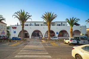 斯塔里格勒Madrugada Old City的一座建筑前的棕榈树停车场