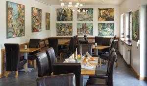 DrefahlDrefahler Landgasthaus的餐厅设有桌椅,墙上挂有绘画作品