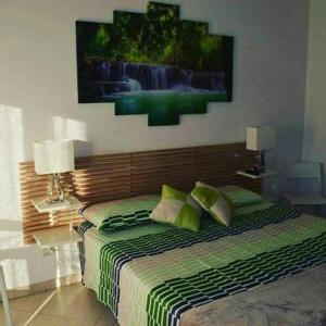 塞拉尔朱斯suite the natural color的卧室配有一张床,墙上挂有绘画作品