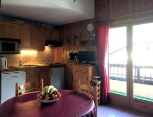 圣热尔韦莱班Les Jardins Alpins - Apartment的厨房配有一张桌子,上面放着一碗水果