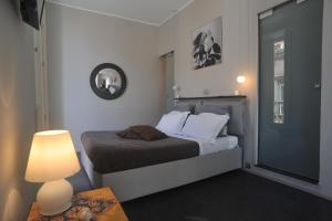 诺托Kalote' Apartments的一间小卧室,配有床和灯